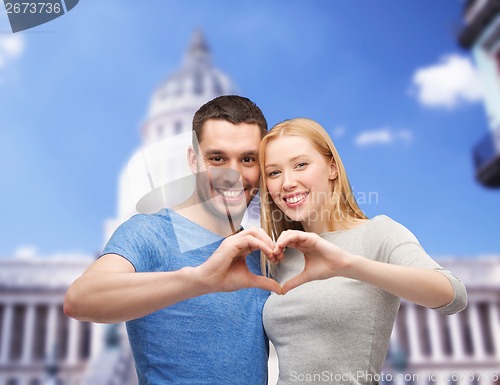 Image of smiling couple showing heart with hands