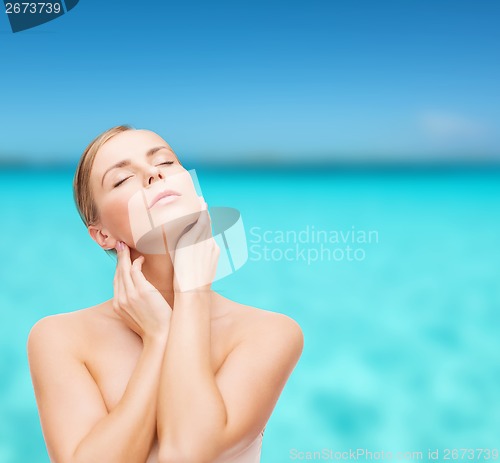 Image of beautiful woman touching her face with closed eyes