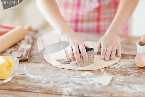 Image of close up of hands making cookies from fresh dough