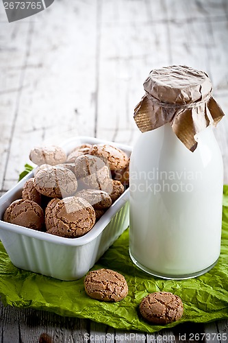 Image of meringue almond cookies in a bowl and bottle of milk 