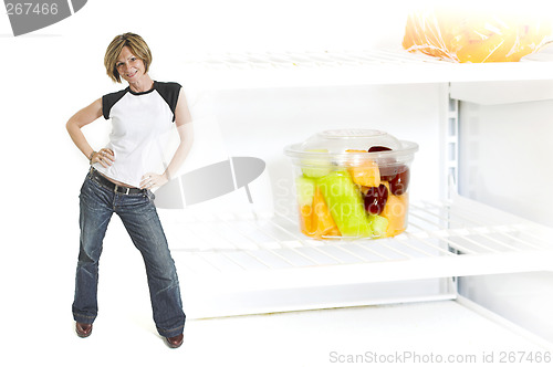 Image of woman beside fruit cup in fridge