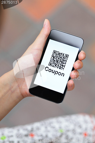 Image of QR coupon on mobile display holding by woman hand