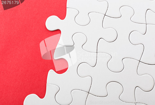 Image of Unfinished puzzle over red background