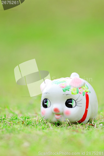 Image of Chinese piggy bank on green grass
