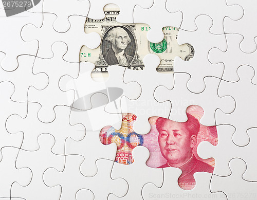 Image of White puzzle with Chinese yuan and US dollar banknote