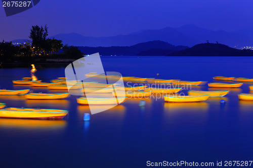 Image of Seascape and small boat at night