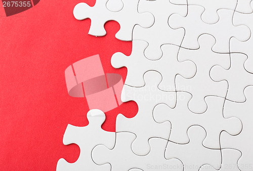 Image of White jigsaw over red background