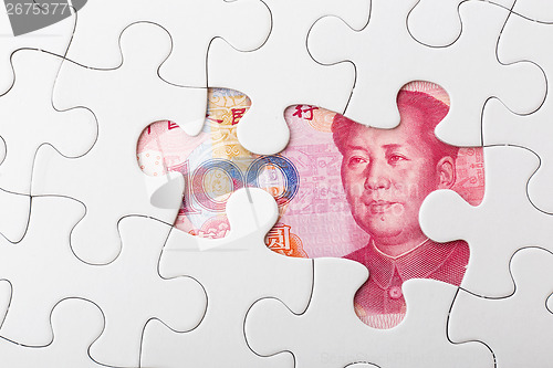 Image of Incomplete puzzle over chinese yuan banknote background