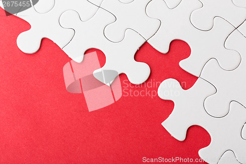 Image of Incomplete puzzle over red background