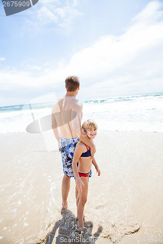 Image of Father and happy young daughter at beach