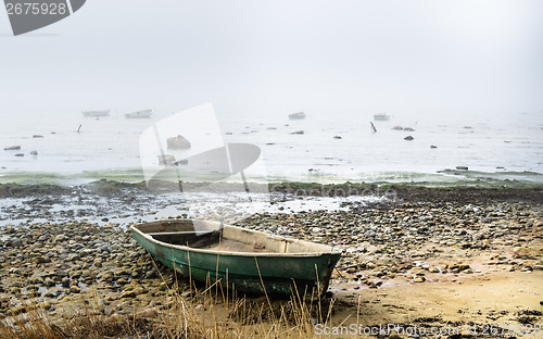 Image of Old fishing boat at coast foggy in the morning