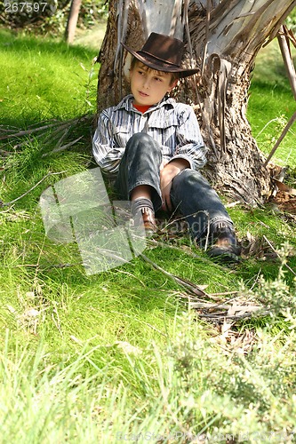 Image of Country boy sitting under a gum tree