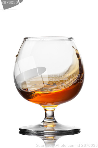 Image of Splash of cognac in glass isolated on white background