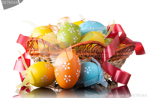 Image of color easter eggs in basket isolated on white