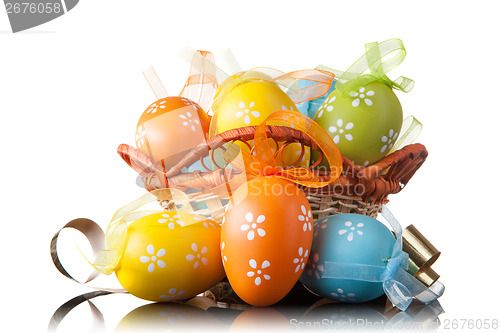 Image of color easter eggs in basket isolated on white