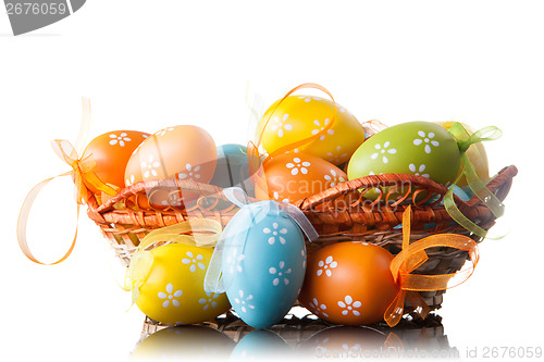 Image of color easter eggs in basket isolated on white