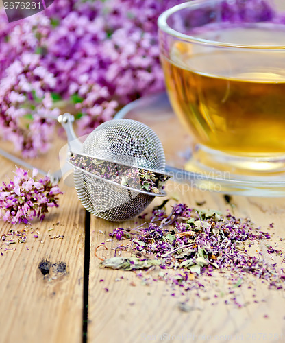 Image of Herbal tea from oregano with strainer on board