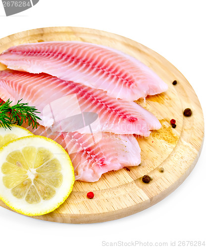 Image of Fillets tilapia with lemon and dill on a board