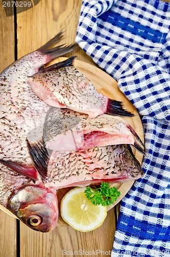 Image of Bream raw on board with a knife and napkin