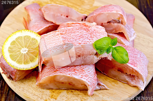 Image of Fillet of sea bass with basil on board