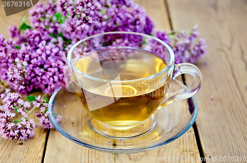 Image of Herbal tea from oregano in a glass cup on board