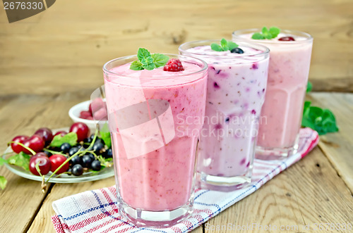 Image of Milkshakes with berries in glass on board