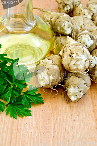 Image of Jerusalem artichokes with carafe of oil on board