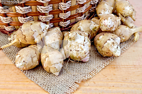 Image of Jerusalem artichokes with a basket and burlap on board