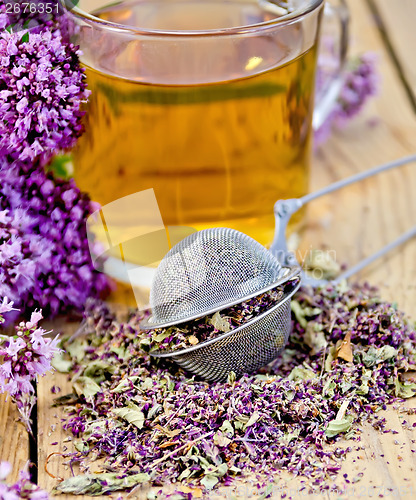 Image of Herbal tea from oregano with strainer in glass mug