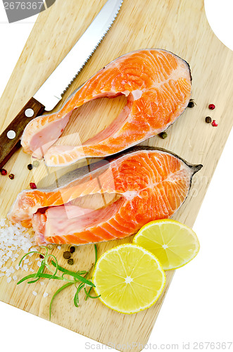 Image of Trout with lemon and knife on plank