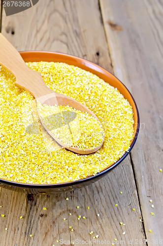 Image of Corn grits in bowl with spoon on board