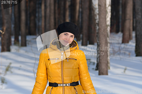 Image of Woman in black beret b yellow jacket on forest background