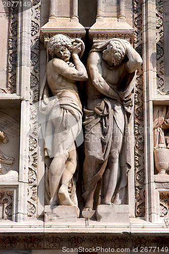 Image of italy two statue of a men in the front of the duomo  