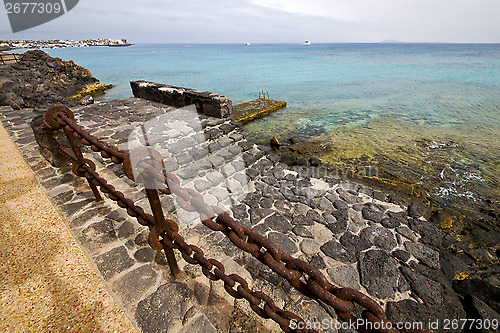 Image of pier rusty chain  water  boat yacht coastline and summer  lanzar