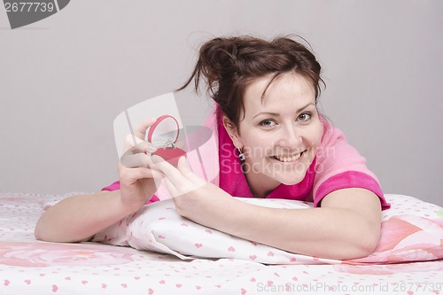 Image of Happy girl with the gift in bed