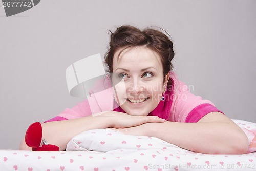 Image of girl is happy with ring, lying in bed