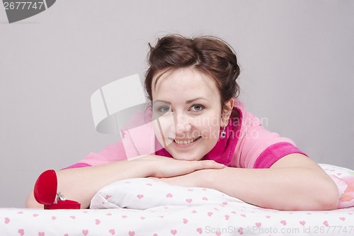 Image of girl is happy with present, lying in bed