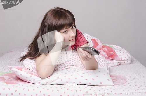 Image of Girl in bed watching TV