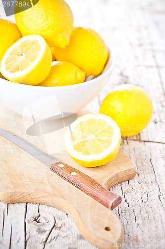 Image of fresh lemons in a bowl and knife 