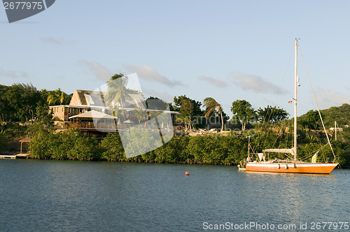 Image of channel in English Harbor with sailboat and luxury villa Antigua