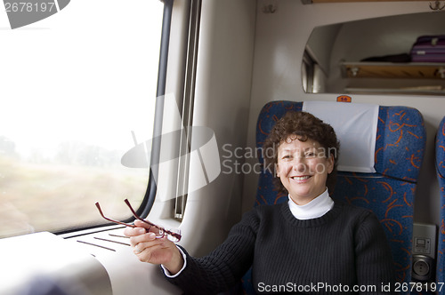 Image of happy female retired middle age senior on first class train in P