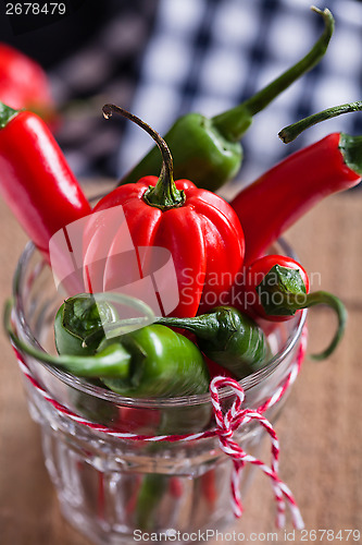 Image of Red and green chili peppers in glass