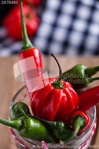 Image of Red and green chili peppers in glass