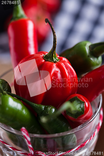 Image of Red and green chili peppers in glass