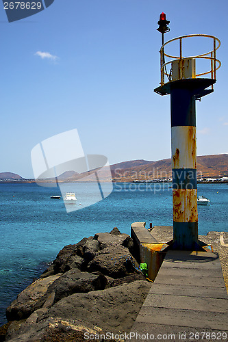 Image of spain lighthouse and harbor pier boat in the blue sky   