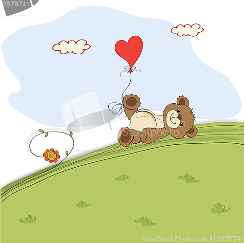 Image of teddy bear with heart on meadow