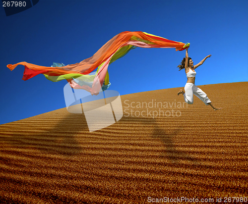 Image of Rainbow woman jumping over the dunes