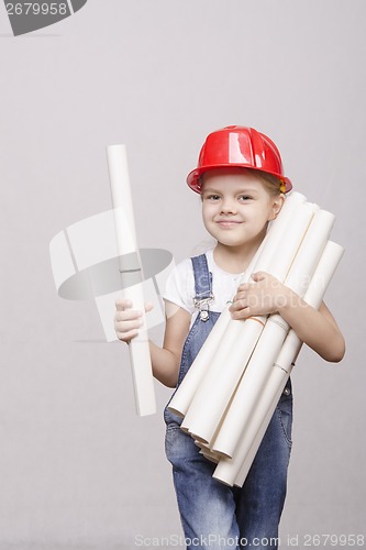 Image of Child architect in helmet stands bunch of drawings