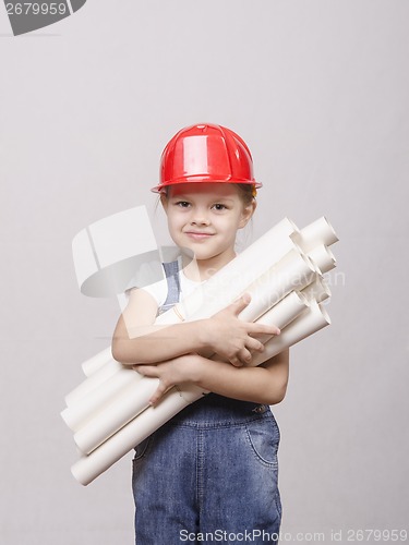 Image of child in helmet stands with a bunch of drawings