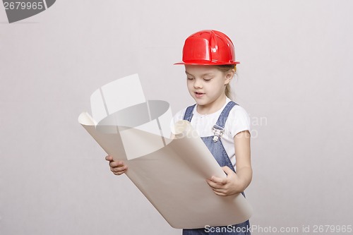 Image of The girl in helmet looks drawing